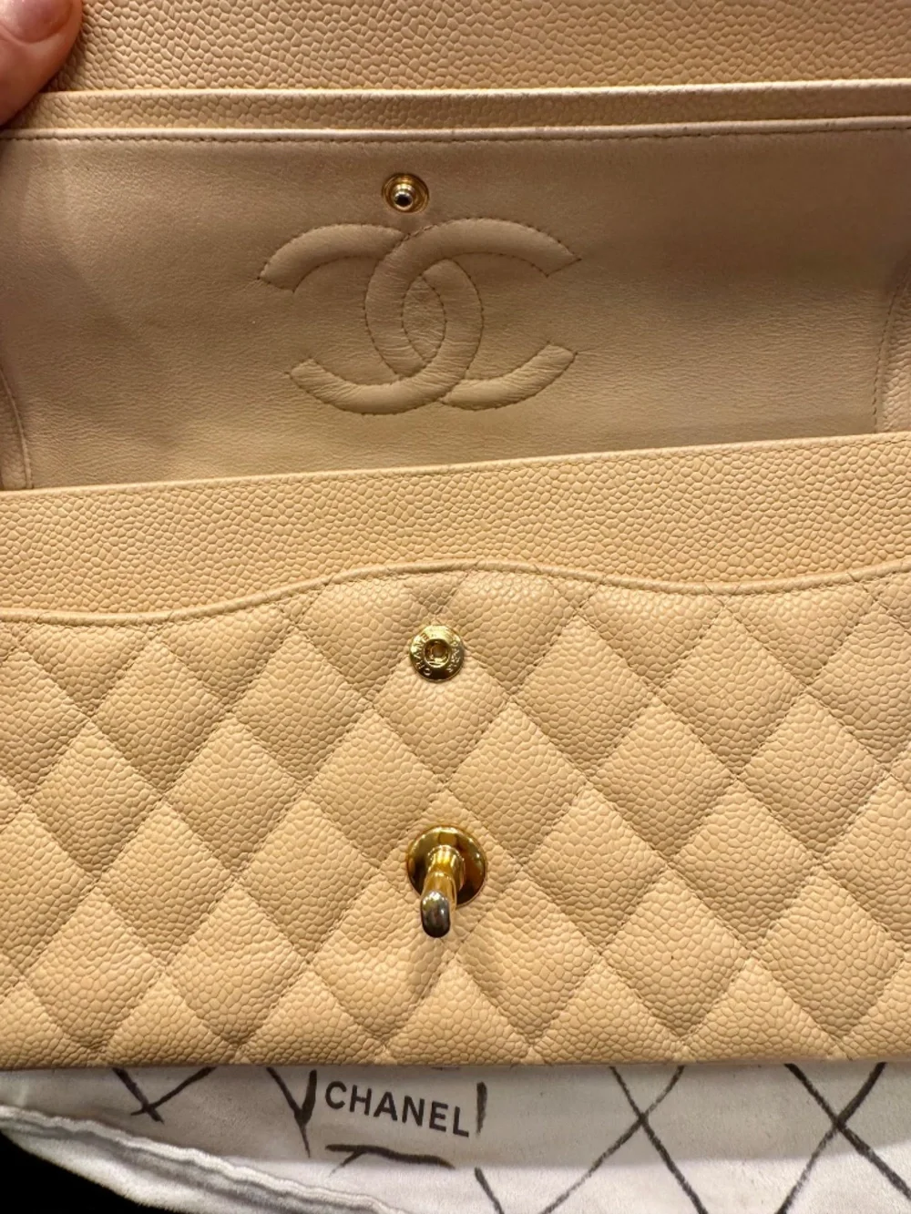 Chanel Classic Medium Double Flap in beige nude caviar with gold tone hardware.